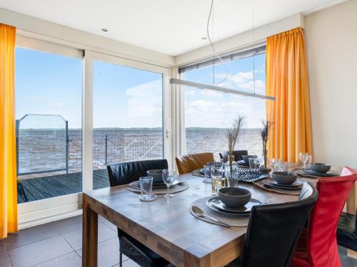a dining room with a table and a large window at Holiday Home Jachthaven Oostmahorn by Interhome in Anjum
