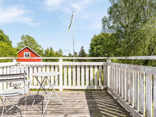 eine Terrasse mit Stühlen, einem Tisch und einer Flagge in der Unterkunft Holiday Home Gåragöl - B in Olofström