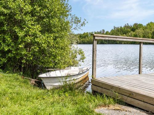 a boat sitting next to a dock on a lake at Holiday Home Gåragöl by Interhome in Olofström
