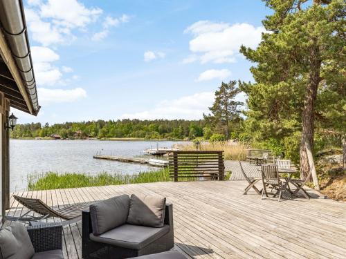 een houten dek met stoelen en een steiger aan een meer bij Holiday Home Bergstigen Gunnebo by Interhome in Gunnebo