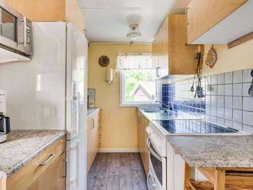 una cocina con electrodomésticos blancos y una ventana en Holiday Home Djursvik by Interhome, en Söderåkra