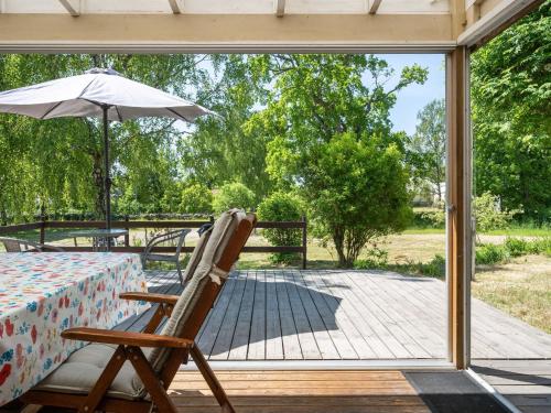 a patio with a table and an umbrella and a chair at Holiday Home Djursvik - SND029 by Interhome in Söderåkra