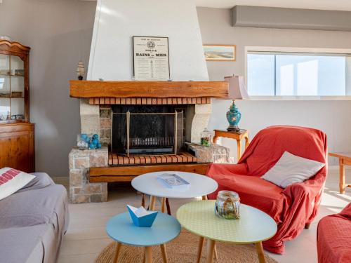 - un salon avec une cheminée et un fauteuil rouge dans l'établissement Holiday Home Le Saint Germ by Interhome, à Saint-Germain-sur-Ay