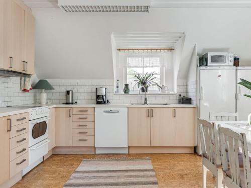 a kitchen with white appliances and a white refrigerator at Holiday Home Matvik by Interhome in Trensum