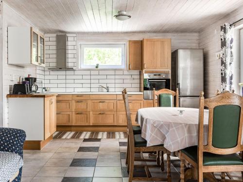 Holiday Home Erikstorp Fyran by Interhome في Olofström: مطبخ بدولاب خشبي وطاولة مع كراسي