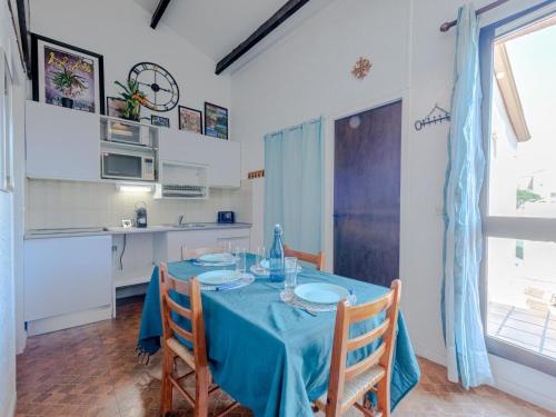 une salle à manger avec une table et des chaises bleues dans l'établissement Apartment Maison des sables 3 by Interhome, à Port-Leucate