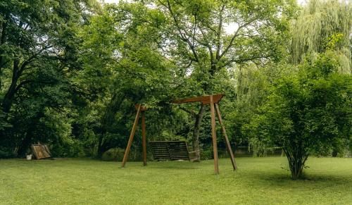 a swing set in a park with a tree at Rudine 41 - Off-Grid Riverside Home in Rokovci
