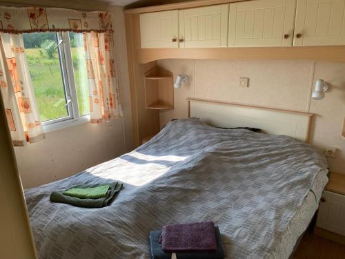 a small bedroom with a bed with a window at Charming house on large property on Vato in Vätö