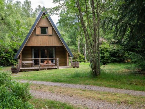 a dog sitting in the window of a cabin at Chalet Rowan Cottage by Interhome in Inverness