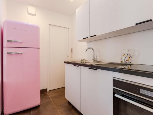 トゥルヴィル・シュル・メールにあるHoliday Home Guillaume le Conquérant by Interhomeのピンクの冷蔵庫(白いキャビネット付)