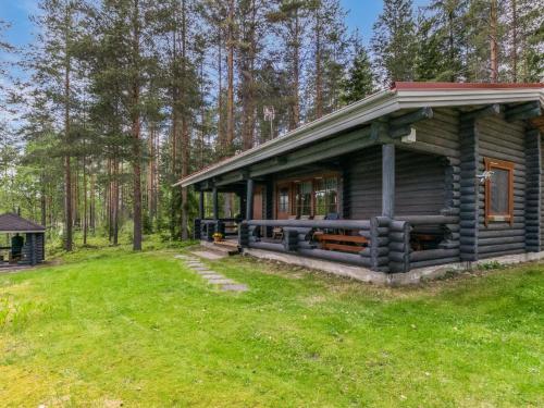 uma cabana de madeira na floresta com um jardim verde em Holiday Home Lohi- cjoe237 a by Interhome em Säynetlahti