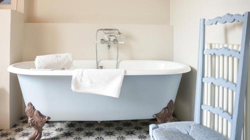 a white bath tub in a bathroom with a crib at Le Clos de Grâce in Honfleur