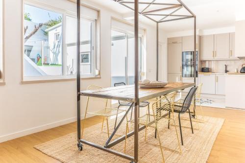 a kitchen and dining room with a table and chairs at 3-bedroom Apt with Private Patio in Cacilhas by Lisbeyond in Almada
