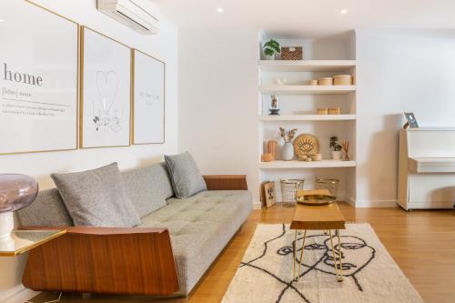 een woonkamer met een bank en een tafel bij Brand New! 3-bedroom Apartment with Private Sunny Patio in Cacilhas! in Almada