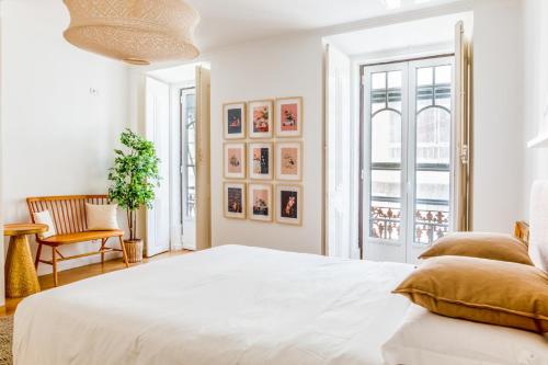 a white bedroom with a large bed and a window at 3-bedroom Apt with Private Patio in Cacilhas by Lisbeyond in Almada