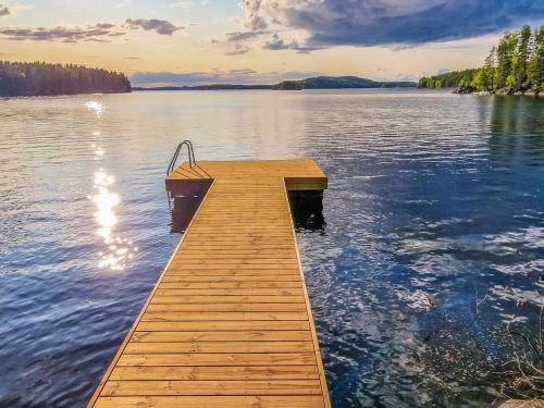 un muelle en un lago con un barco en él en Holiday Home Kiviranta by Interhome, en Savonlinna