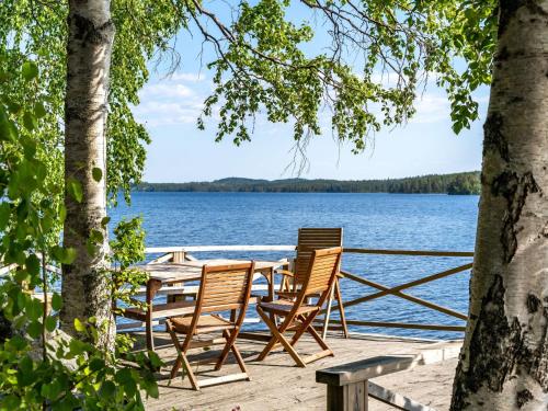 una mesa y sillas en un muelle junto al agua en Chalet Villa Lundsfjärden - VML120 by Interhome en Grythyttan