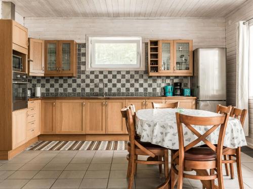 a kitchen with a table with chairs and a refrigerator at Holiday Home Erikstorp Femman - B in Olofström