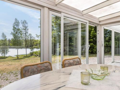 a dining room with a table and a large window at Holiday Home Erikstorp Femman by Interhome in Olofström