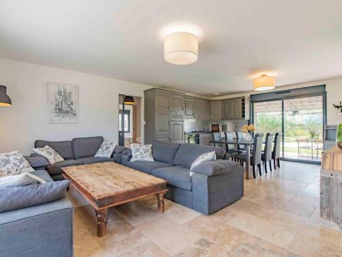 a living room with a couch and a table at Holiday Home L'Oliveraie by Interhome in Saint-Didier