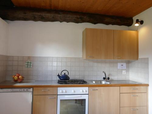 uma cozinha com armários de madeira e um forno com placa de fogão em Holiday Home Rustico Edel by Interhome em Acquacalda