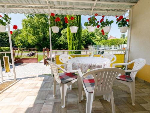 uma mesa e cadeiras num pátio com flores em Holiday Home Gizella by Interhome em Balatonlelle