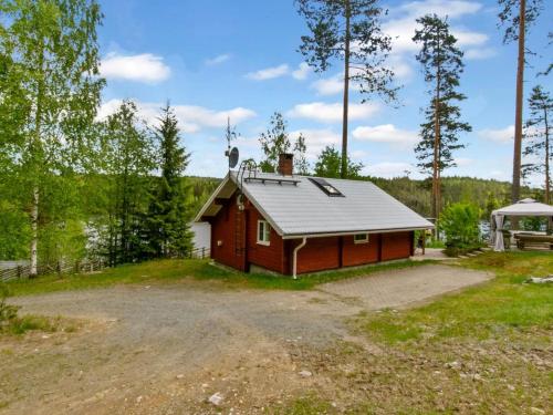 uma pequena cabine vermelha no meio de um campo em Holiday Home Cjoe239 by Interhome em Pölläkkä