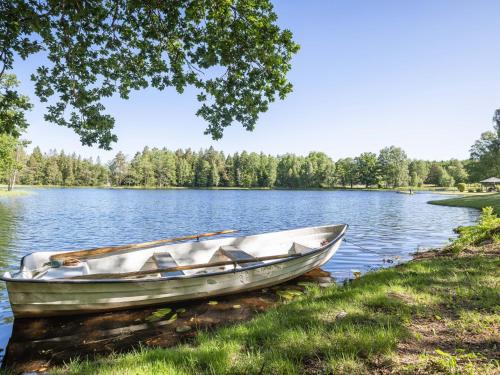a boat sitting on the shore of a lake at Holiday Home Norrviken by Interhome in Unnaryd