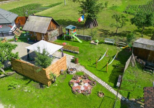 - une vue aérienne sur une cour avec une maison et une aire de jeux dans l'établissement Casuta de Vacanta Poiana, à Poiana Teiului
