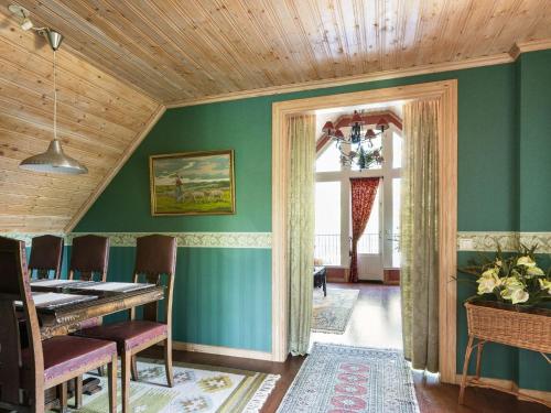 a dining room with green walls and a wooden ceiling at Holiday Home Norrviken by Interhome in Unnaryd