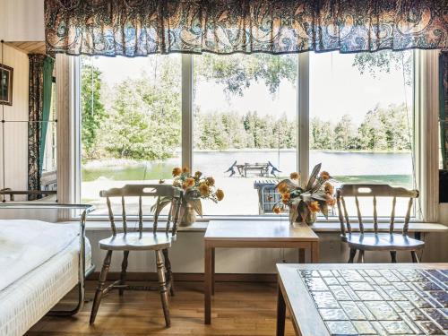 a bedroom with a table and chairs and a large window at Holiday Home Norrviken by Interhome in Unnaryd