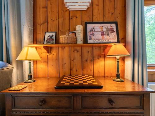 two lamps on a dresser with a chessboard on it at Holiday Home Kerrow Cottage by Interhome in Inverness