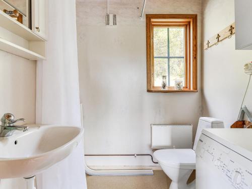 a white bathroom with a sink and a toilet at Holiday Home Bofall by Interhome in Södra Vi