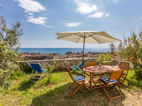tavolo e sedie con ombrellone e oceano di Holiday Home Il Giardino sul Mare by Interhome a Castiglioncello