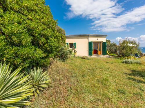 una piccola casa su una collina con un verde cespuglio di Holiday Home Il Giardino sul Mare by Interhome a Castiglioncello