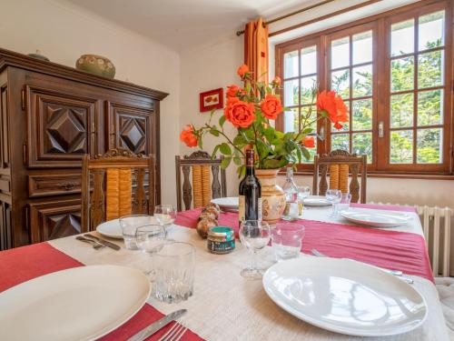 - une table à manger avec des assiettes blanches et des fleurs dans l'établissement Holiday Home Ker Vian by Interhome, à Tréflez