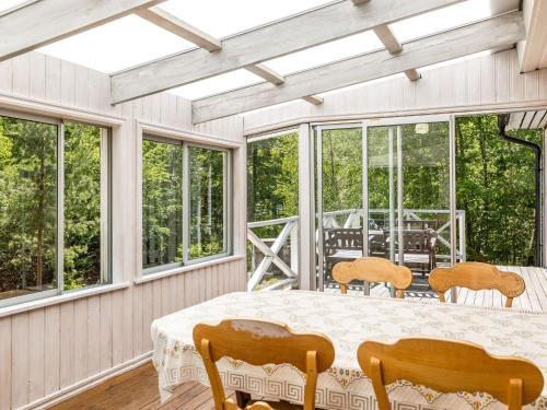 uma sala de jantar com mesa, cadeiras e janelas em Holiday Home Erikstorp Trean by Interhome em Olofström