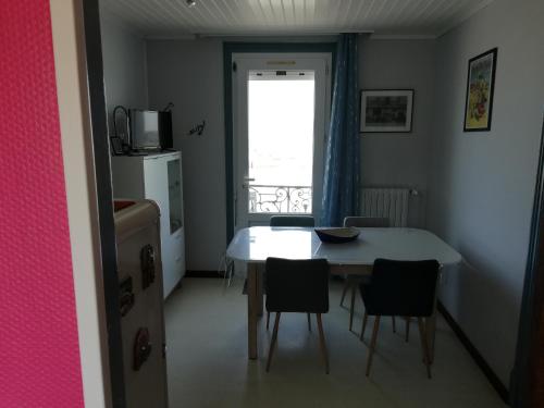 une cuisine avec une table et des chaises et une fenêtre dans l'établissement Superbe vue mer Quai 39, au Tréport