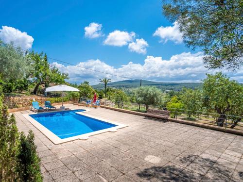 una piscina in un giardino con una persona seduta su una panchina di Holiday Home Can Pere Mas by Interhome a Pòrtol