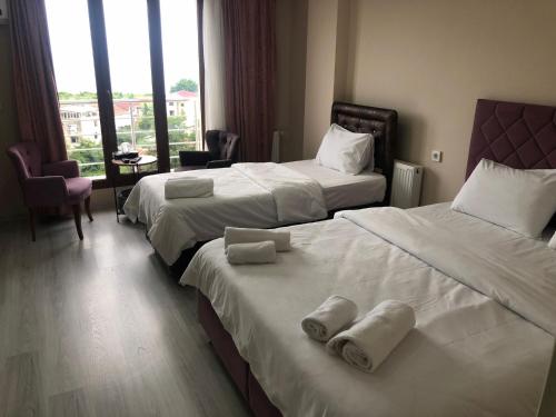 two beds in a hotel room with towels on them at ELİSA Park Hotel in Trabzon