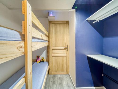 Cette petite chambre comprend 2 lits superposés et une porte. dans l'établissement Apartment Pegase Phenix-72 by Interhome, au Corbier
