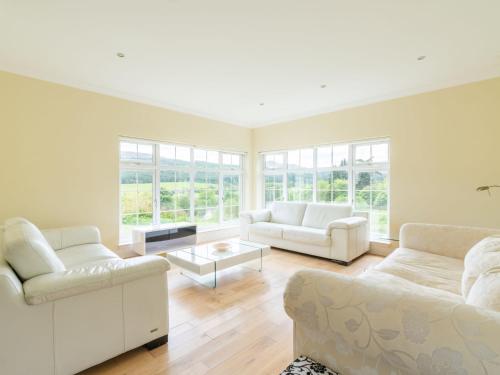 a living room with two white couches and a table at Holiday Home Bearnock House by Interhome in Drumnadrochit