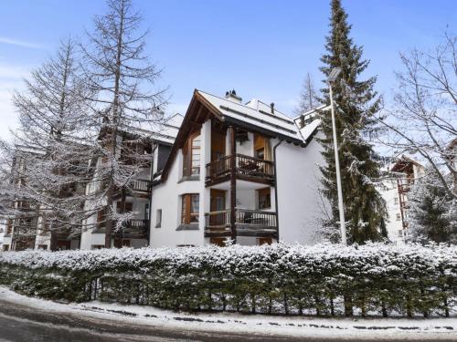 una casa cubierta de nieve con una valla en Apartment Schweizerhof 501 Mü by Interhome, en Lenzerheide