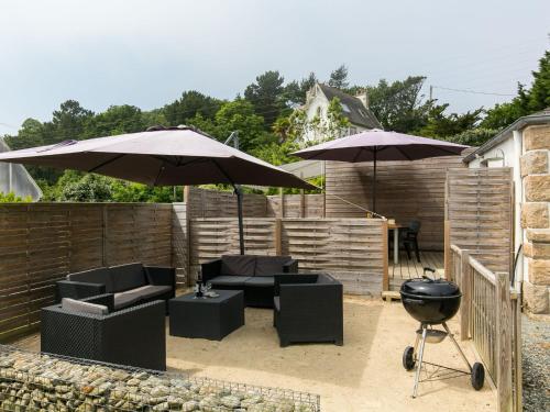 un patio avec deux parasols et des chaises et un barbecue dans l'établissement Holiday Home Le Coup de Coeur by Interhome, à Locquirec