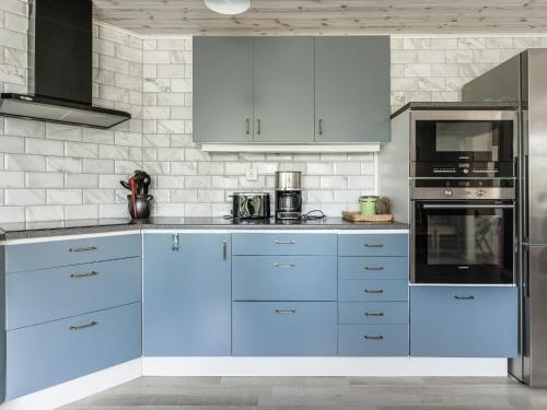 a kitchen with blue cabinets and appliances at Holiday Home Erikstorp Villan by Interhome in Olofström