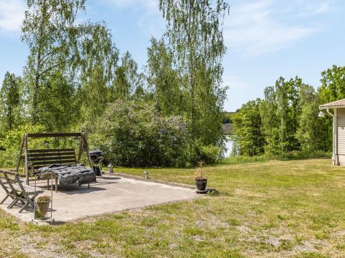 un banc de parc assis sur un trottoir à côté d'un lac dans l'établissement Holiday Home Erikstorp Villan by Interhome, à Olofström