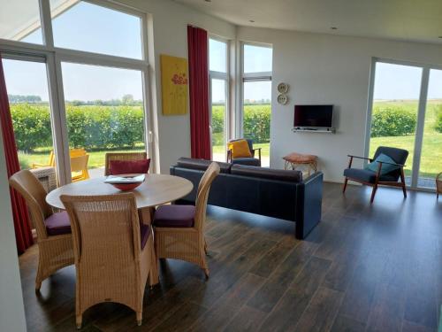 a living room with a couch and a table and chairs at Holiday Home Ruisweg 51 by Interhome in Wemeldinge