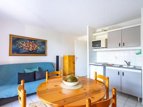 une cuisine et une salle à manger avec une table en bois dans l'établissement Apartment Le Domaine d'Azur-3 by Interhome, au Lavandou
