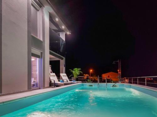 a swimming pool on the side of a building at night at Holiday Home Emili & Elias by Interhome in Karlobag