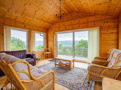 Una sala de estar con un sofá y sillas y ventanas. en Holiday Home Achmony Number 7 by Interhome, en Drumnadrochit